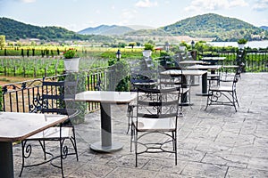 Table and chairs in the balcony of outdoor restaurant view nature farm and mountain background - dining table on the terrace