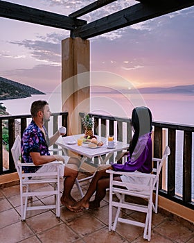 Table and chairs with breakfast during sunrise at the meditarian sea in Greece