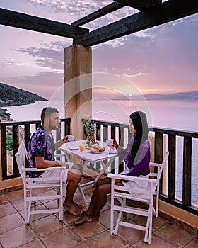 Table and chairs with breakfast during sunrise at the meditarian sea in Greece