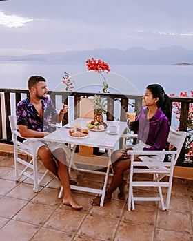 Table and chairs with breakfast during sunrise at the meditarian sea in Greece