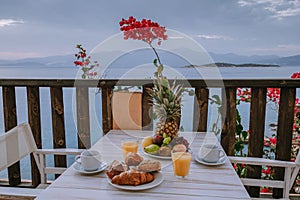 Table and chairs with breakfast during sunrise at the meditarian sea in Greece