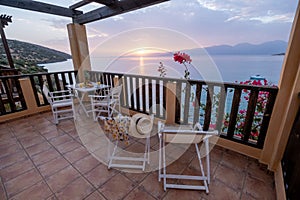 Table and chairs with breakfast during sunrise at the meditarian sea in Greece