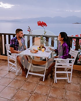 Table and chairs with breakfast during sunrise at the meditarian sea in Greece