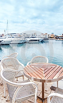 Table and chairs in cafe on pier, rest and sea travel background
