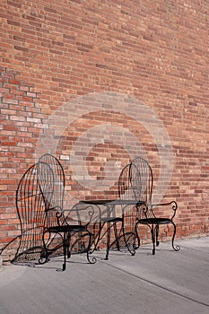 Table and chairs at an old brick storefront