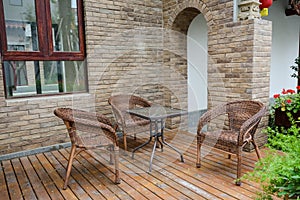 Table and chairs on planked ground before traditional building