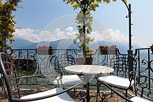 Table and chairs on a terrace overlooking lake and mountains in