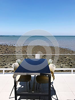 Table and chairs on the terrace of a restaurant on the beach
