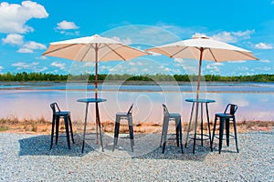 Table and chairs and umbrellas.on blue sky background