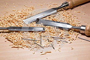 Table with chisel blades and shavings of wood sawdust and nails work of an artisan carpenter.