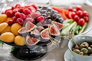 Table with cold snacks and tableware. Fresh Fruit platter on banquet table at business or wedding event venue. Raspberry photo