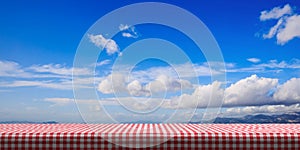 Table covered with red tablecloth on blue sky background, copy space. 3d illustration