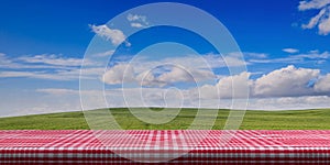 Table covered with red tablecloth on blue sky background, copy space. 3d illustration