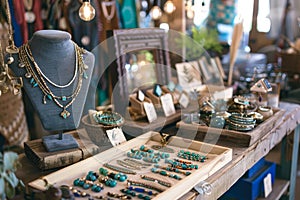 A table covered in a variety of handmade jewelry pieces, showcasing the unique craftsmanship and creativity of the boutique, A