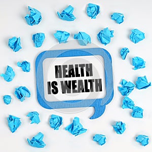 On the table are crumpled blue pieces of paper and a thought plate with the inscription - Health Is Wealth