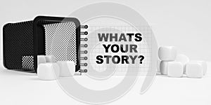 On the table are cubes, a small basket and a notebook with the inscription - WHATS YOUR STORY