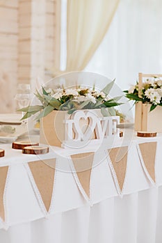 Table decor with white flowers and candles for a wedding party.