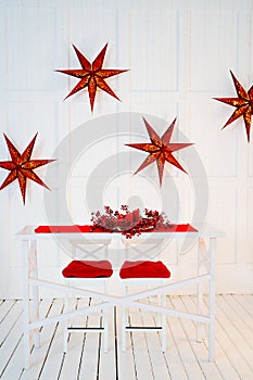 table is decorated for new year with red tablecloth, wreath and candles.