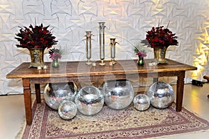 Table decorated with vases of flowers and vases with Venetian masks and mirror balls