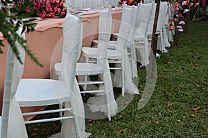 Table decoration with clean white chairs at a wedding.