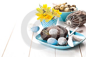 Table decoration with easter eggs nest on plate