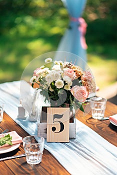 Table decoration with number. Elegant wedding table arrangement, floral decoration, restaurant.