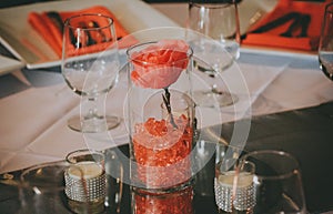 Table decoration with a rose in glass vase.