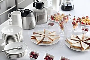 Table with different delicious snacks and dishware indoors. Coffee break