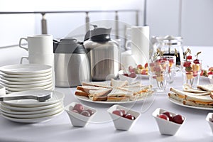 Table with different delicious snacks and dishware indoors. Coffee break