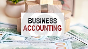 On the table are dollars and a sign on which it is written - BUSINESS ACCOUNTING. Finance and economics concept