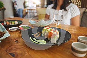 Table, eating and people with sushi at a restaurant for fish, Chinese food or hungry. Closeup, plate and a person with