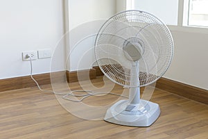 Table electric fan sit on the wooden floor