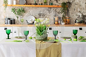Table festive setting with tulips flowers and stabilization moss in glass vase. Wedding table decoration.