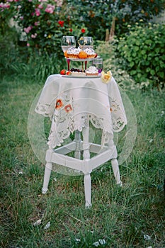 Table with festive treat and tablecloth in the summer garden