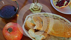 On the table are festive treats for Rosh Hashanah challah, honey, and pomegranate