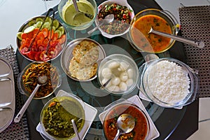 Table filled with fresh homemade gujarati food is seen from above. Traditional indian vegetarian kathiyawadi thali