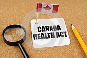 On the table is the flag of Canada, a pencil and a sheet of paper with the inscription - Canada Health Act