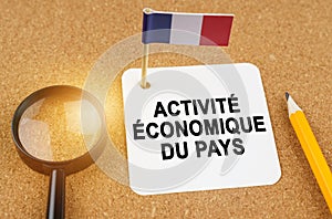 On the table is the flag of France and a sheet of paper with the inscription - economic activity of the country