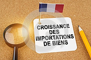 On the table is the flag of France and a sheet of paper with the inscription - growth in imports of goods