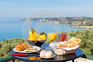 Table with food and drinks in front of blue sea and beach