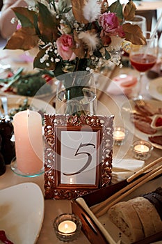Table with food, flowers, candles and table number.
