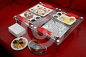 Table with the food in the restaurant in a red interior