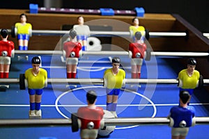 Table football soccer game. kicker. sports team players in red and yellow t-shirts