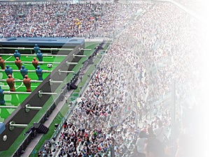 Table football toy and soccer ball inside a real stadium