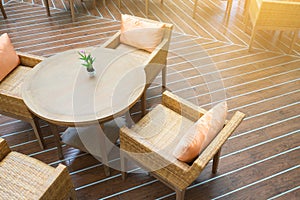 Table with four chairs in the sun on wooden floor