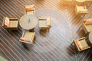 Table with four chairs in the sun on wooden floors