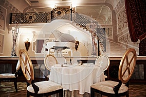 Table for the four people is ready to receive rich visitors. Interior of luxury restaurant in vintage aristocratic style