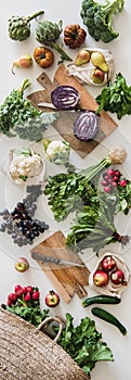 Table with fresh seasonal vegetables, greens, fruit, vertical composition