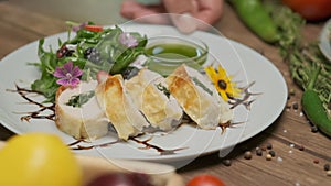 Table with fresh vegetables, spices and chicken roll with spinach