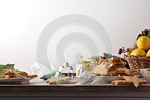 Table with freshly prepared cookies and Christmas decoration isolated white